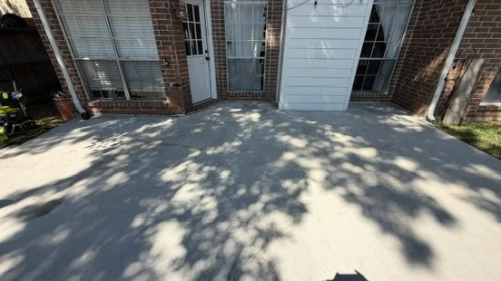 The same patio after cleaning, with tree shadows across the lighter surface